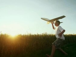 Young boy flys an airplane in the country Stock Footage
