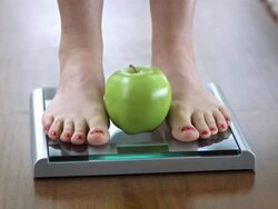 HD DOLLY: Feet And An Apple On Bathroom Scale Stock Footage