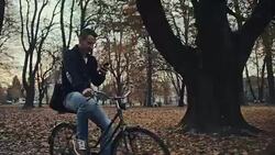 Man typing sms while riding a bicycle through the park Stock Footage
