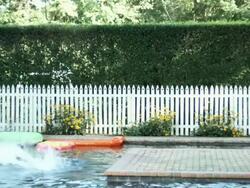 Boy and girl running and jumping into swimming pool, slow motion Stock Footage