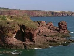 Aerial over Arbroath Cliffs bordering the North Sea / Aberdeenshire, Scotland Stock Footage