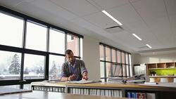 Architect reviewing blueprint proofs at table in office library Stock Footage