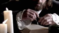 Nostradamus removes the stopper from a vial and reads a book by candlelight. Stock Footage
