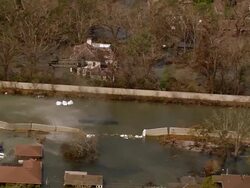 Aerial Chinook helicopter flying sandbags to levee breach / zoom out flooded city / New Orleans, Louisiana Stock Footage
