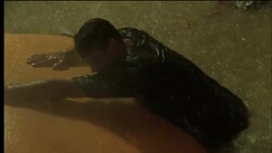 A man struggles to cling to the roof of a car sinking in deep water. Stock Footage