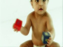 CU baby boy in nappy sitting on floor, playing with building blocks Stock Footage
