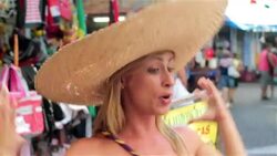 Brazilian woman tries on sombrero and laughs with boyfriend in Rio marketplace Stock Footage