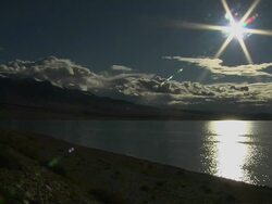 Block Shot Shimmering Mansarovar Lake with sun flare Lhasa Tibet China Stock Footage