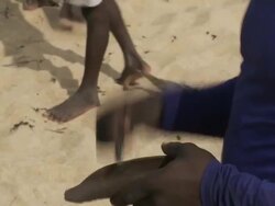 C/U Beninese fisherman ringing bell to set net-pulling pace Stock Footage
