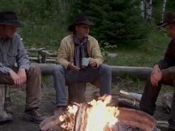 Cowboys sit around a fire at dusk Stock Footage