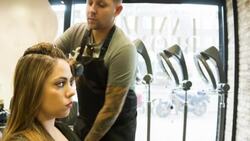 Male Hair stylist drying a female clients hair Stock Footage