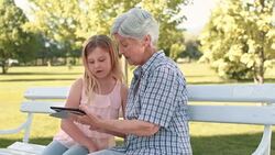 Granddaughter teaching grandma how to use a tablet Stock Footage