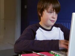 BOY AGED 12 AT LAPTOP IN BEDROOM FOREGROUND Stock Footage