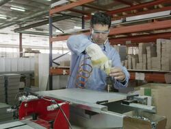 MS worker screwing metal rails onto piece of furniture in furniture factory Stock Footage