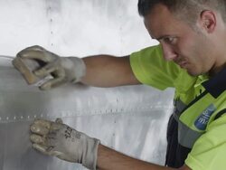 CU aircraft mechanic sanding down airplane stripped back to aluminum hull, RED R3D 4K Stock Footage