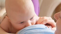 Mother breastfeeding her baby lying on back Stock Footage