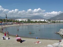 WS View of Tourist resting and enjoying in front of lighthouse at beach of Costa del Sol and Puerto Banus near Marbella / Puerto Banus, Andalusia, Spain Stock Footage