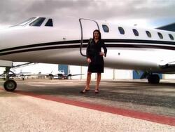 Wide shot pan Businesswoman standing on runway near private jet at Opa Locka Airport/ Miami, Florida, USA Stock Footage