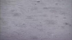 Rainwater splashes as it falls on pavement. Stock Footage