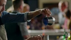 Precise bartender mixes flaming cocktail in crowded bar Stock Footage