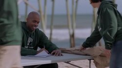 Volunteer welcomes in fellow volunteers at check in booth Stock Footage