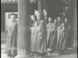 1944: BUDDHIST MONASTERY: * VS Buddhist temple w/ large Buddha statue on mountain side, various monks walking, male ringing large bell w/ wooden, Buddhist monks in courtyard praying, bowing. Buddhism, religion, philosophy, enlightenment Instructional Video