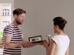 MS Young couple hanging photograph on wall / Berlin, Germany Stock Footage