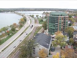 High Angle static - Traffic drives along a lakeside highway in Wisconsin. / Wisconsin, USA Stock Footage