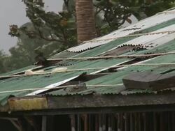 Tin roof of hut blows damaged in strong winds from typhoon. Super Typhoon Megi or Juan, NE Luzon, Philippines Oct 2010 / AUDIO Stock Footage