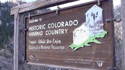 A sign in the mountains reads, Welcome to Historic Colorado Mining Country. Stock Footage