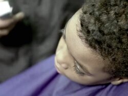 CU HA Barber shaving boy's (8-9) hair at barbershop, Brooklyn, New York City, New York State, USA Stock Footage