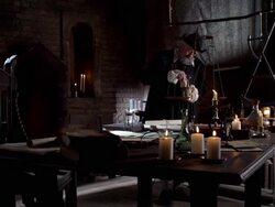 Nostradamus picks up a powder from a scale, adds it to a bowl, and begins mixing. Stock Footage