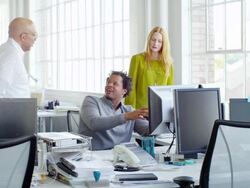 MS group of colleagues discussing project in informal meeting at office workstation Stock Footage