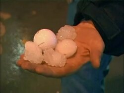 CU Hand holding large hailstones alongside golf ball, Iowa, USA Stock Footage