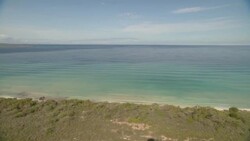 Gentle waves wash onto a rocky shore. Stock Footage
