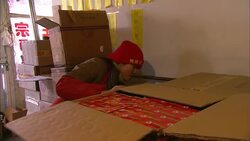 A clerk removes a box of merchandise from a cardboard box and takes it through a sliding glass door. Stock Footage