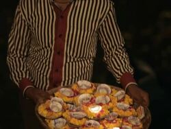 MS TD Man holding offerings of flowers and lit oil lamps / Varanasi, India Stock Footage