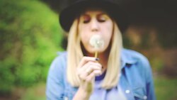 woman blowing on a dandelion Stock Footage