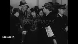 1936: PROFESSIONAL RUMORMONGER: DRAMATIZATION: EXT MS Two men in hats &amp; coats exiting building revolving doors. MS Two men rehearsing lines '... I got it.' VS Two men in elevator, subway talking about presidential nominees' lack of health (SOT). Instructional Video