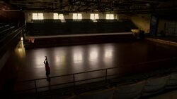 A basketball player gets his own rebound as he practices shooting three-pointers in a dark gymnasium. Stock Footage