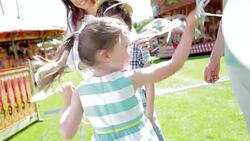 Girl tangled in balloons at amusement park Stock Footage