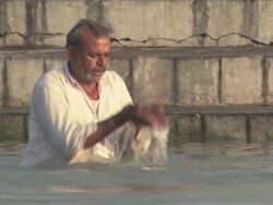 MS Elderly man scooping up water with hands and praying while standing in the Ganges river / Kashi, Uttar Pradesh, India Stock Footage