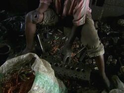 MS Shot of men breaking up metal components / Lagos, Nigeria Stock Footage