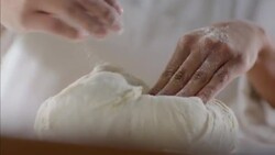 Baker kneads and shapes dough with her hands Stock Footage