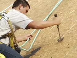 MS Worker removing nails on roof of red building / Chelsea, Michigan, United States Stock Footage