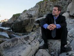 MS Man sitting on rocks looking out over ocean / Portland, ME, United States Stock Footage