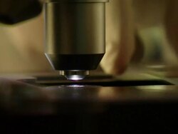 Extreme Close Up static - A gloved hand pushes a glass slide under a microscope. Stock Footage