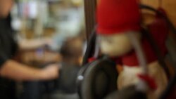 Barber trims customer's goatee with electric clippers in neighborhood barbershop Stock Footage