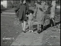 1946: TRADITIONAL FAMILY:  Female mother & male father (neck down) walking on suburb sidewalk holding hands of young child jumping, hopping up & down between parents as they walk. Cute, childlike enthusiasm, childhood. Instructional Video