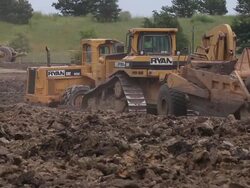 Caterpillar bulldozers and soil compactors excavate soil at a building site Stock Footage